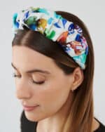 Three-quarter view of a woman wearing the Maria Blueberry Headband, eyes closed, showcasing the accessory's fit and style.