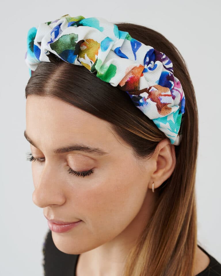 Three-quarter view of a woman wearing the Maria Blueberry Headband, eyes closed, showcasing the accessory's fit and style.