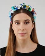 Frontal view of a woman wearing the Maria Blueberry Headband, showcasing its vibrant floral print on a white fabric.