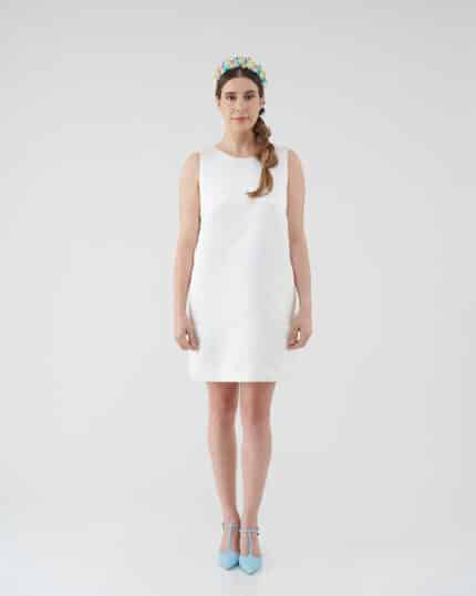 Elegant model in a Maria Daisy Mini Dress paired with the vibrant Tulip Headband, standing confidently in blue ankle-strap heels against a white backdrop.
