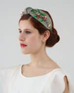 Profile view of a model wearing the Greenery Headband, showcasing the hand-embroidered foliage and floral details with sequins, paired with the off-white Maria Jasmine Mini Dress.